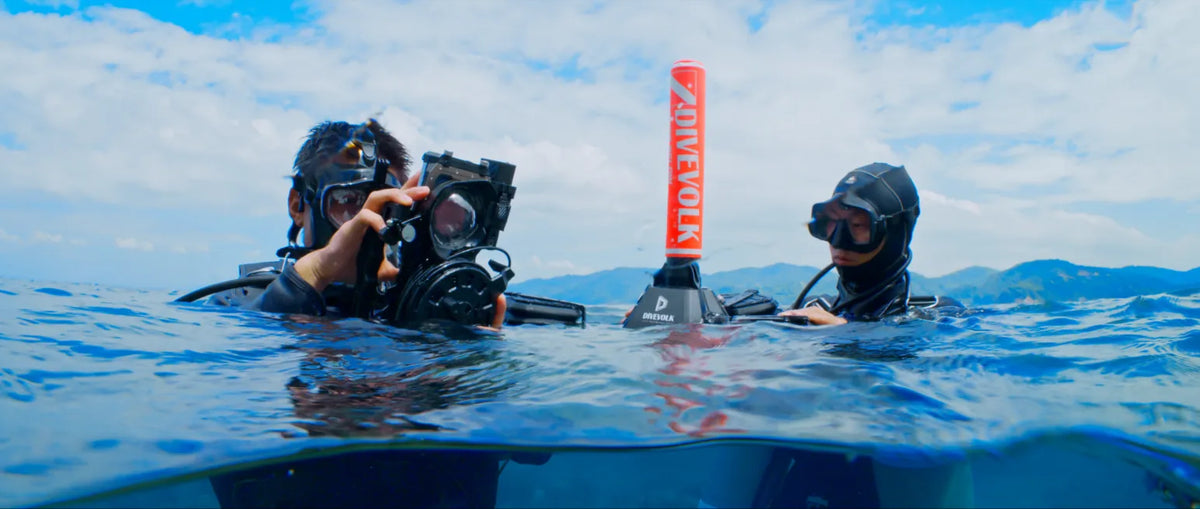 divers set up livestream at surface with sealink float