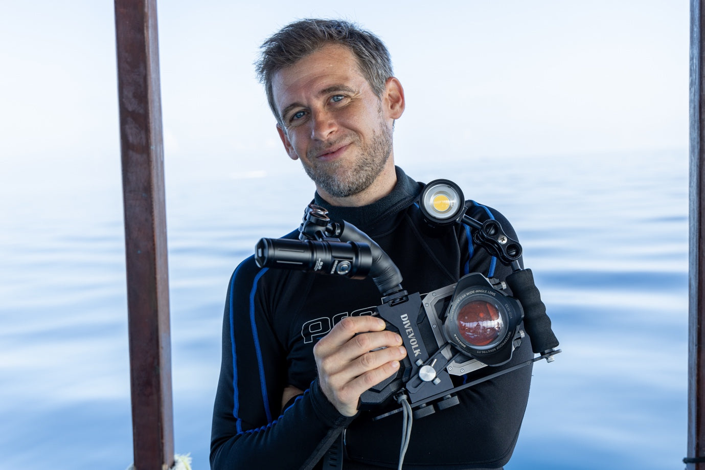 Underwater cinematographer Matthias Lebo holding DIVEVOLK SeaTouch underwater smartphone rig with wide angle lens and dual video lights