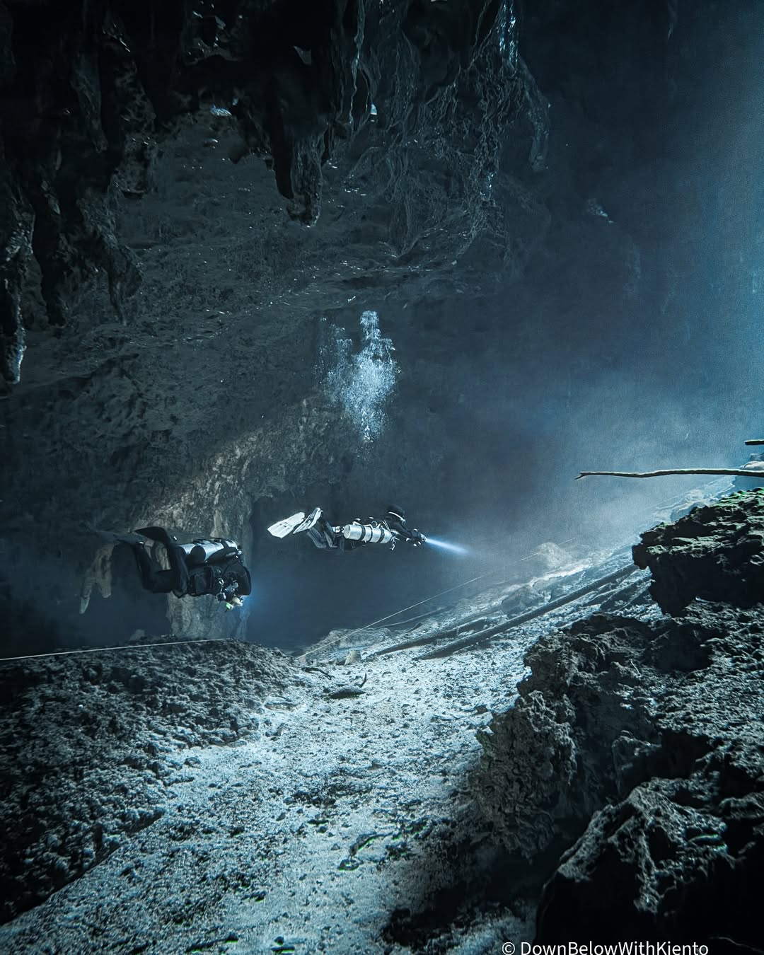 A diver exploring an underwater cave with the SeaTouch 4 Max Plus Housing, showcasing the mysterious and adventurous atmosphere of cave diving with clear details and dramatic lighting.