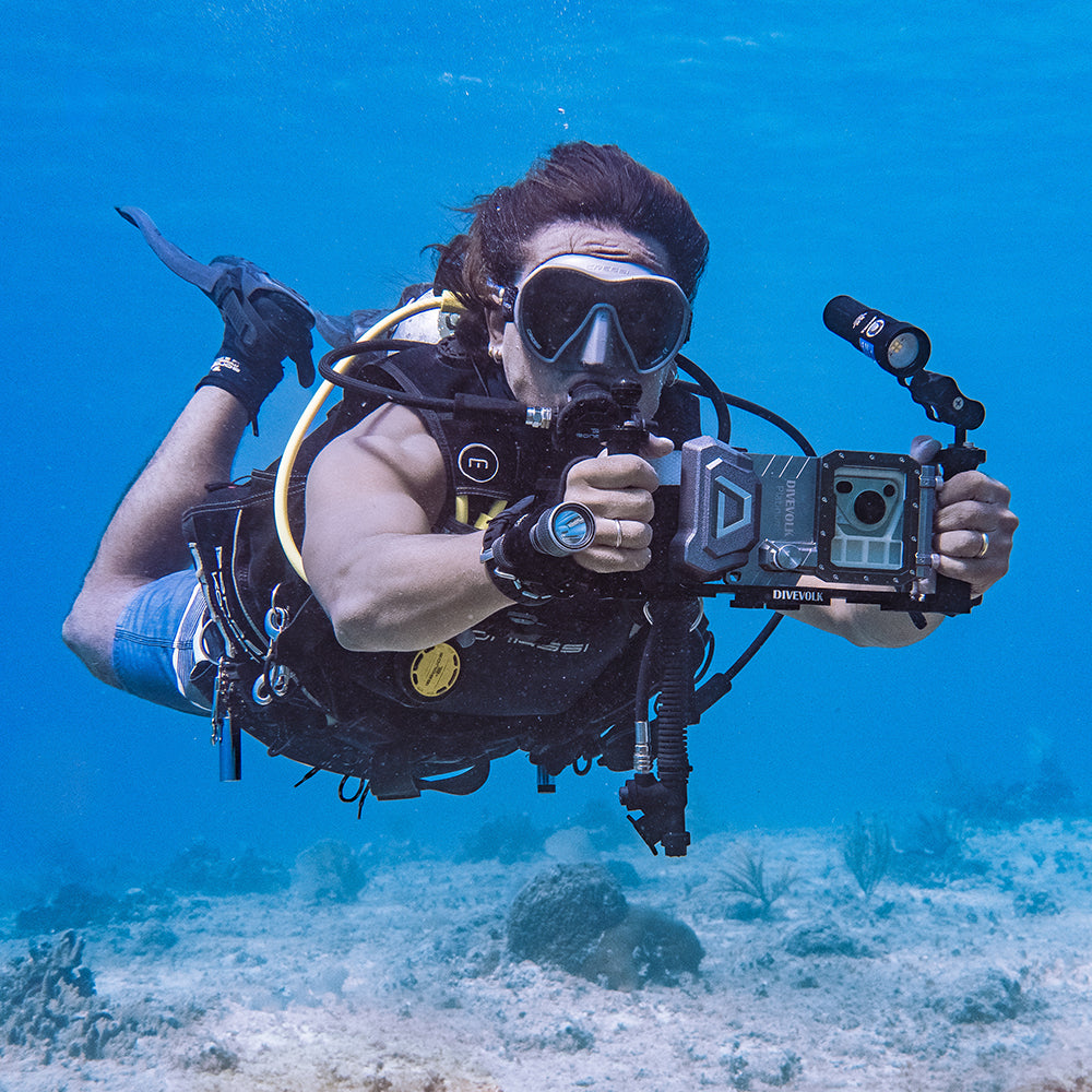 Diver using DiveVolk dual handle underwater phone housing.