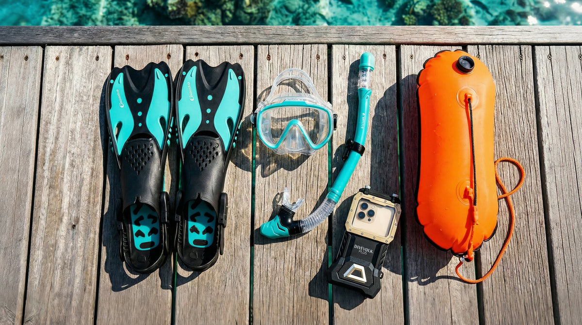Safe snorkeling gear flat lay on wooden dock with traditional mask snorkel fins reef-safe sunscreen and orange safety float with tropical ocean in background