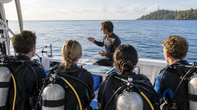 Beginner divers listening to an instructor during a briefing on a dive boat deck