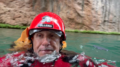 Miguel Ollero, dive instructor and aquatic rescue trainer, swimming in a canyon pool in a red rescue helmet