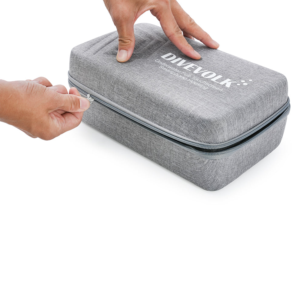 Hands zipping open DIVEVOLK travel case — grey EVA hard shell with heavy-duty zipper showing compact and portable design.
